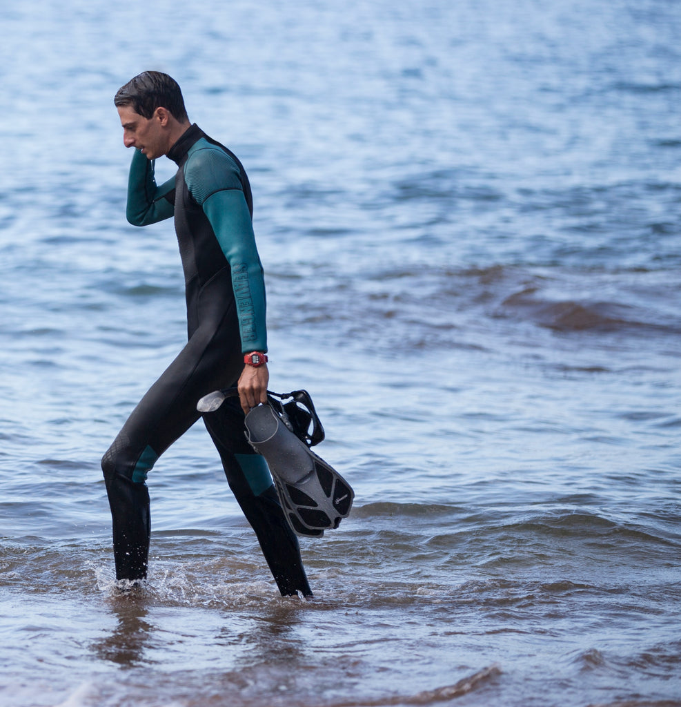 men's black surfing wetsuit with teal sleeves and a sharkskin chest